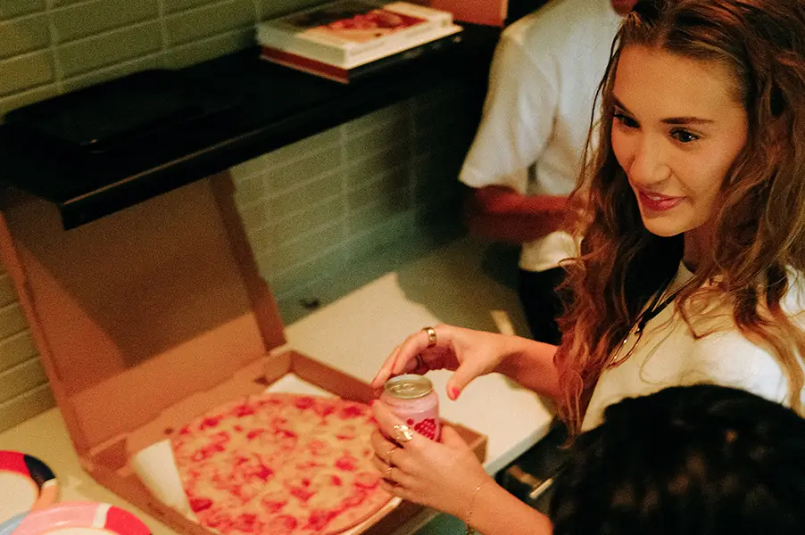 a woman next to a pizza box